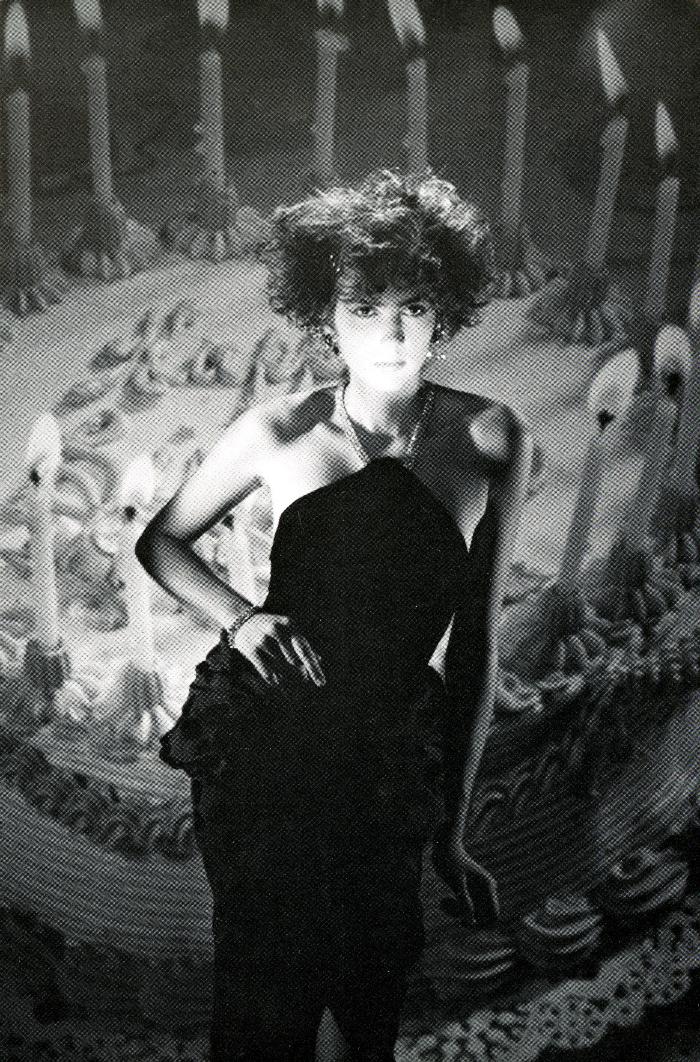 Announcements and invitations depicts: black and white photograph of a woman in front of a giant birthday cake with candles
