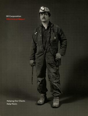 Annual Reports and Corporate Communications depicts: A man wearing coveralls and a headlamp, he hold some sort of metal tool 