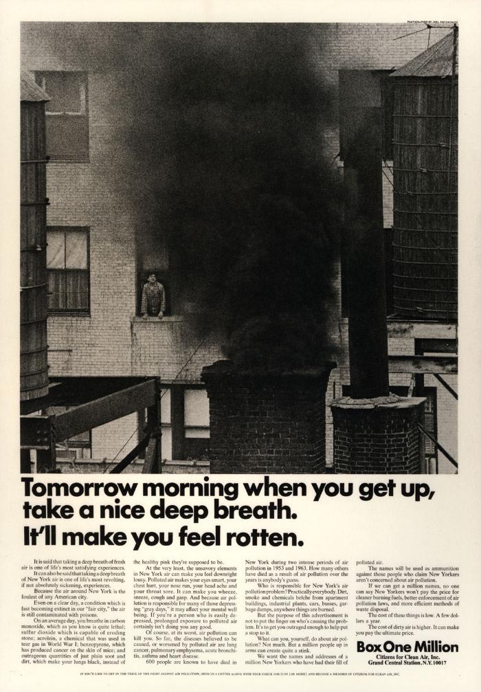 Advertisements depicts: Man looks out a window to see a chimney with a plume of black smoke coming out 