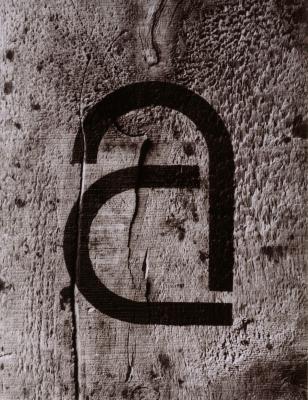 Photographic Materials, Logos and identities depicts: A large lower case "A" is stenciled on a piece of wood 