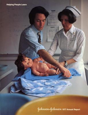 Annual Reports and Corporate Communications depicts: A nurse and a man in a button up and tie practicing taking care of a baby doll