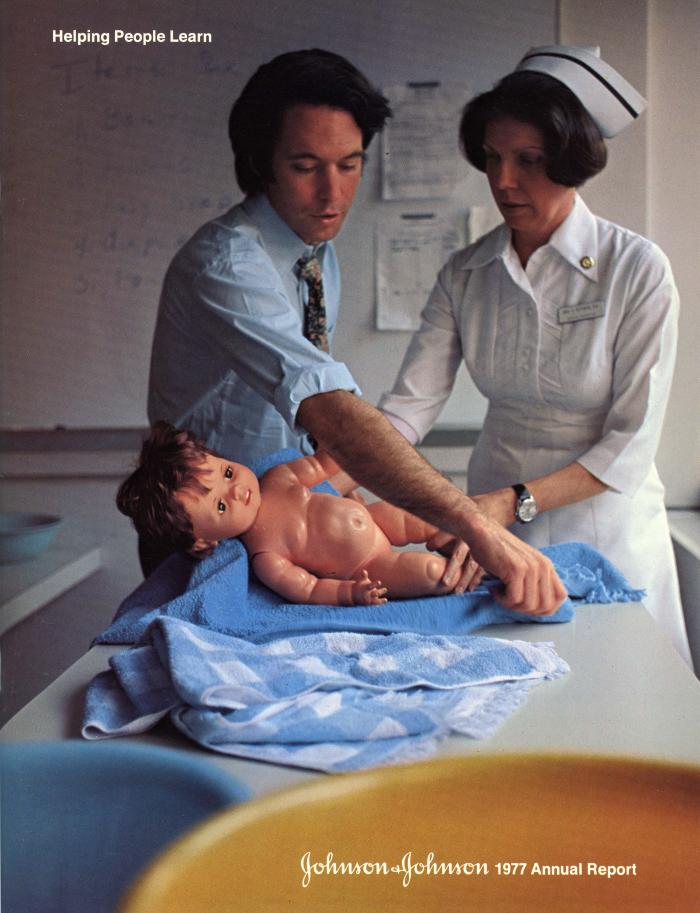 Annual Reports and Corporate Communications depicts: A nurse and a man in a button up and tie practicing taking care of a baby doll
