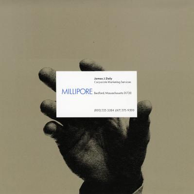 Graphic Standards Manuals, Logos and identities depicts: A hand holding a Millipore business card 