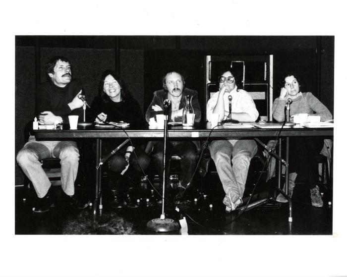 Photographic Materials depicts: black and white photograph of full panel at table with microphones