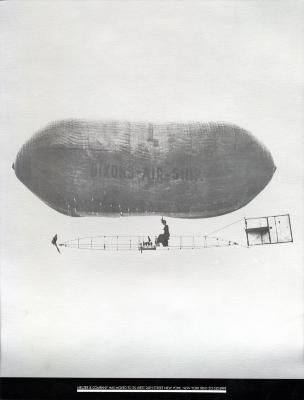 Posters depicts: Black and white photo of an old fashioned blimp moving across the sky.