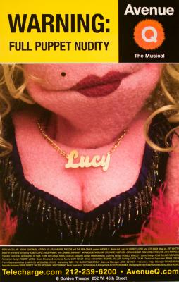 Posters depicts: Lady puppet with red lips, a mole, cleavage with a low cut dress, and a gold necklace that says Lucy.