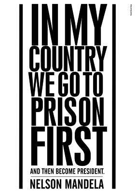 Posters depicts: Mandela quote, "In my country we go to prison first and then become president" in black block letters on white background.