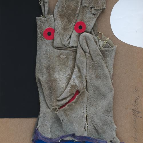 Smashed and torn work glove with two red dots for eyes