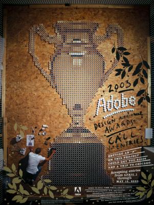 Posters depicts: overhead view of trophy shape made up of coffee cups; a person is shown putting the cups in place.