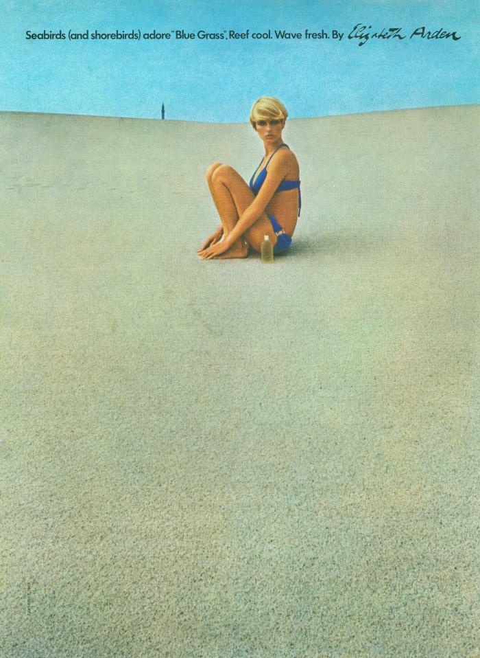 Advertisements depicts: Blonde woman in blue bikini sitting on sand on a beach. There are no footprints leading to her.
