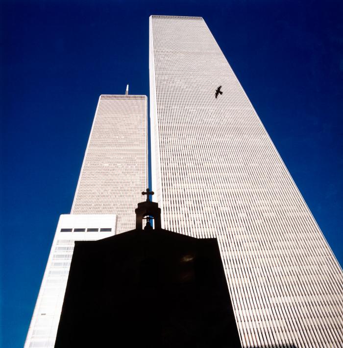 Photographic Materials depicts: The twin towers photographed from street level, with a silhouettes of St. Nicholas Greek Orthodox Church in the foreground and of a bird in mid-flight.