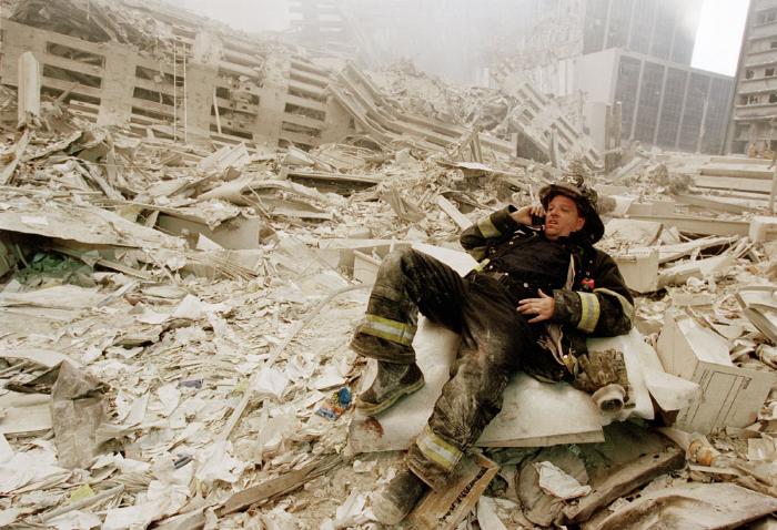 Photographic Materials depicts: Fireman lying among the rubble of the twin towers, holding a cell phone to his ear
