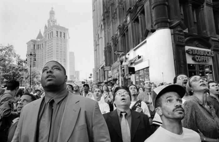 Photographic Materials depicts: A crowd of people stand in front of a Starbucks, gazing up with their mouths agape