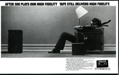 Advertisements depicts: Man sitting in chair facing an amplifier, the sound is blowing back his hair, tie, and the lampshade on the light next to him