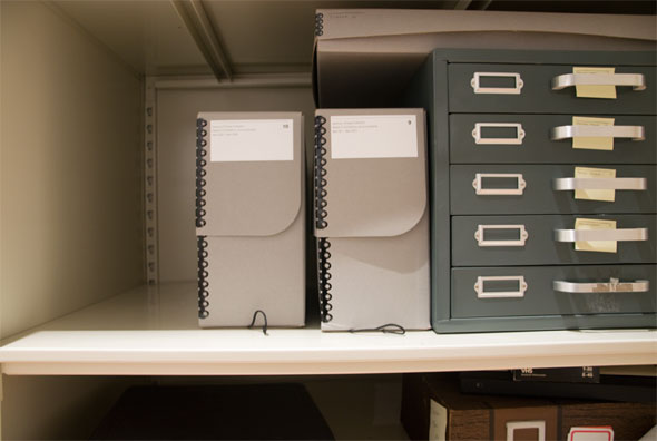 Photo of two grey boxes and flat files in the archives