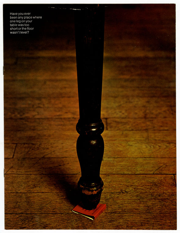 Color photo of a red matchbook under a table leg. Small column of white text reads "Have you ever been any place where one leg on your table was too short or the floor wasn't level?"