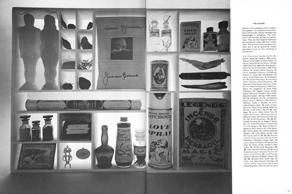 Black and white photograph of objects stored in a grid, including male and female shaped candles, a "Love Spray" perfume, and jars of liquid.