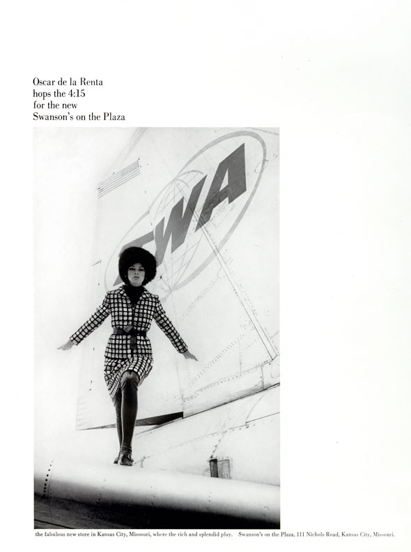 A black and white photo of a woman in a grid-patterned dress, posing on top of a tailplane. 