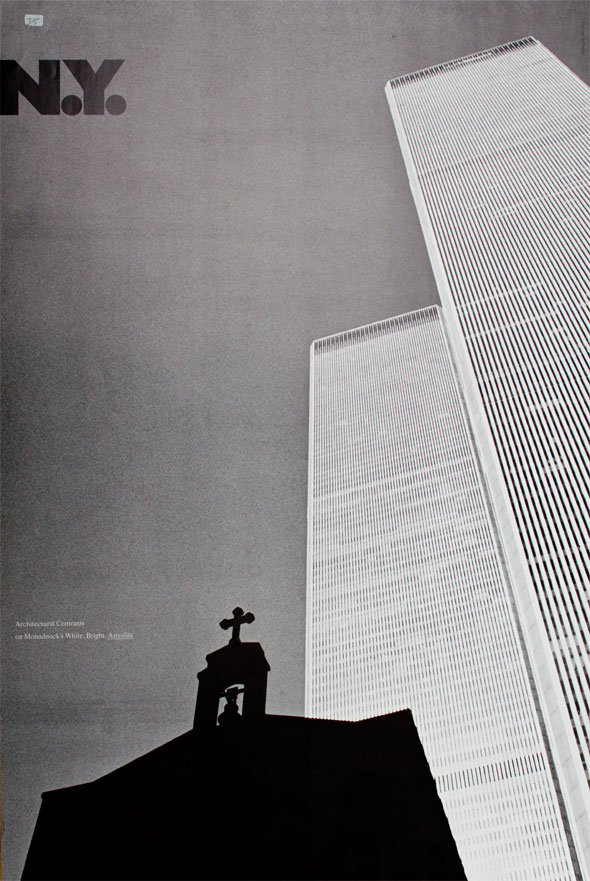 Ground view black and white photograph of two buildings; a shadowed church steeple is visible in foreground